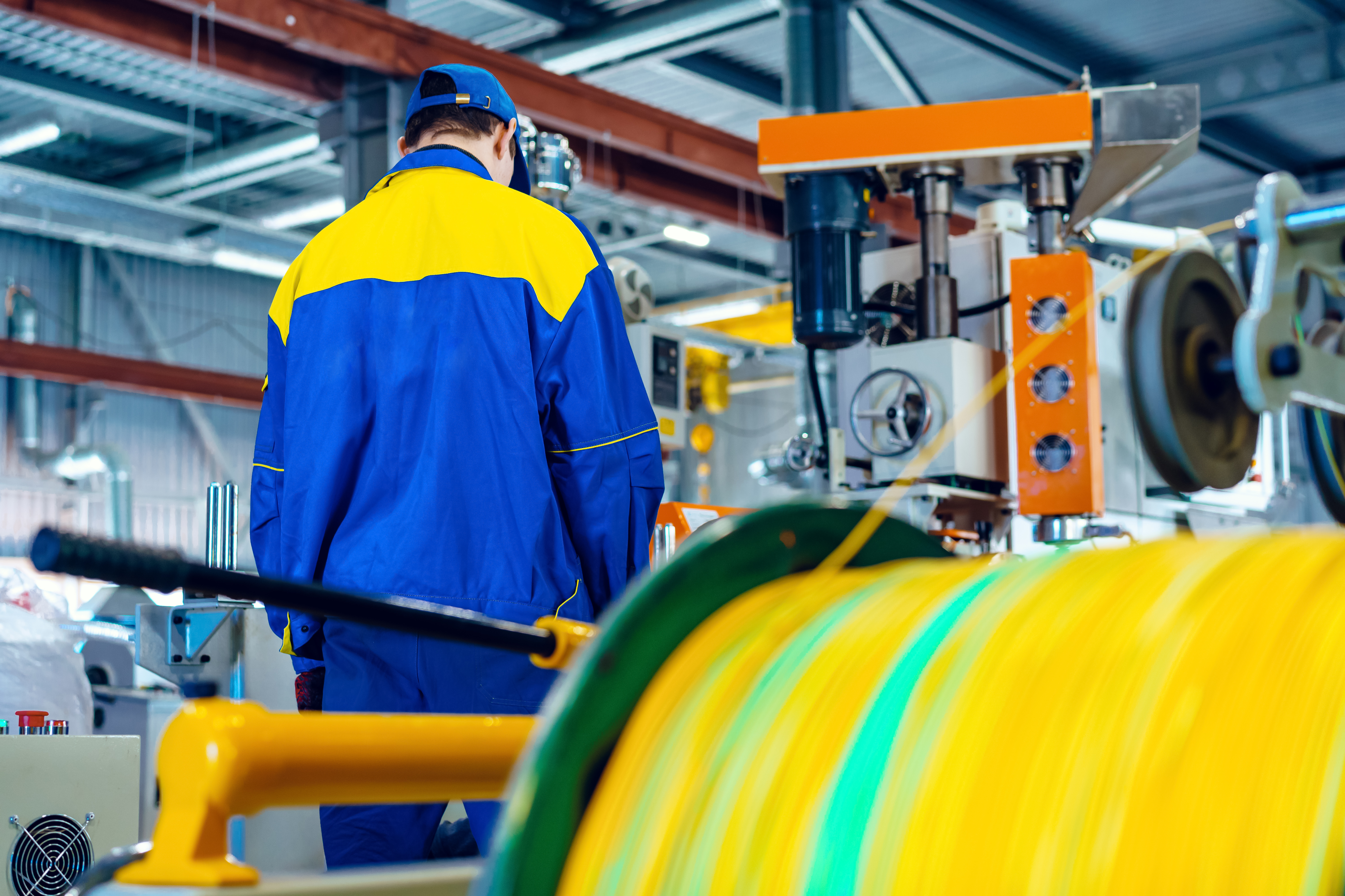 Man worker in manufacturing plant at cable factory machine control computer panel, close up
